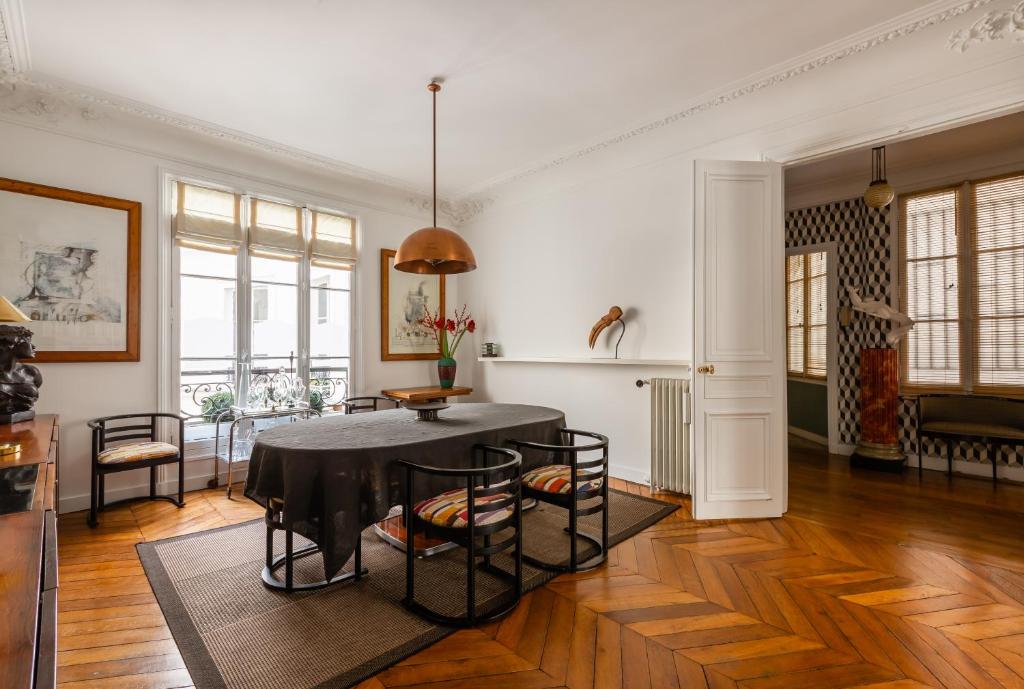 a living room with a black table and chairs at Veeve - Artistic in Pigalle in Paris