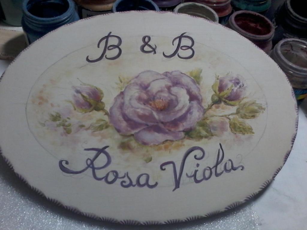 un gâteau avec une fleur rose dans l'établissement B&B RosaViola, à Teulada