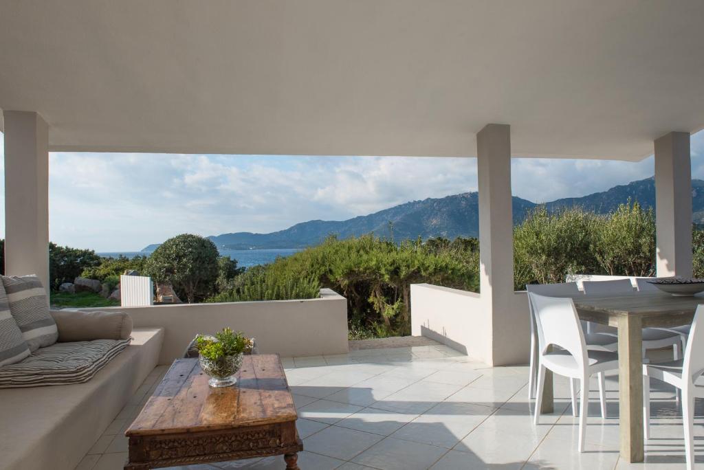 ヴィッラシミーウスにあるSul Mare Sardegna Villa Calipsoの海の景色を望むパティオ(テーブル付)