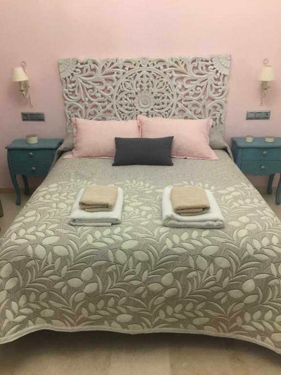 アンテケラにあるAp. Palacete Marqués d la Vegaのベッドルーム1室(大型ベッド1台、青いテーブル2台付)