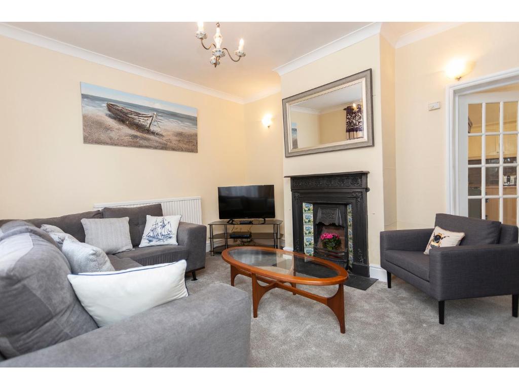 a living room with a couch and a table and a tv at Sandown Villa Holiday Home in Deal