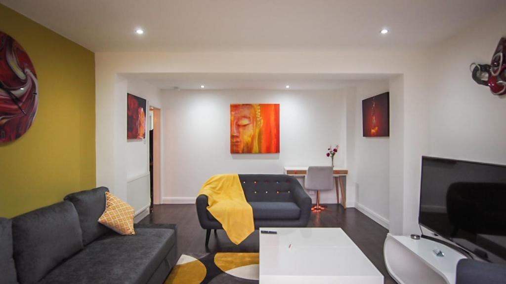 uma sala de estar com um sofá e uma mesa em Ur City Pad - 4 bedrooms - 4 bathrooms - Somerset House em Birmingham