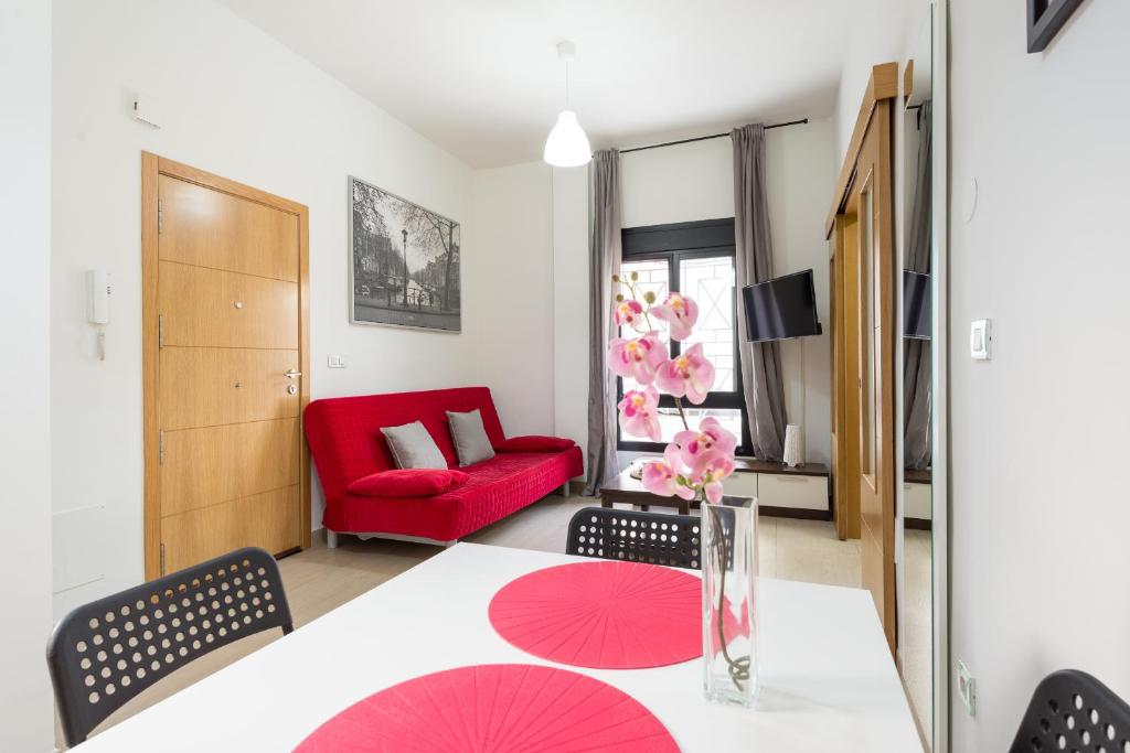 salon ze stołem i czerwoną kanapą w obiekcie MABB-Quiet Apt With Private Patio Walking Distance To Downtown w Maladze