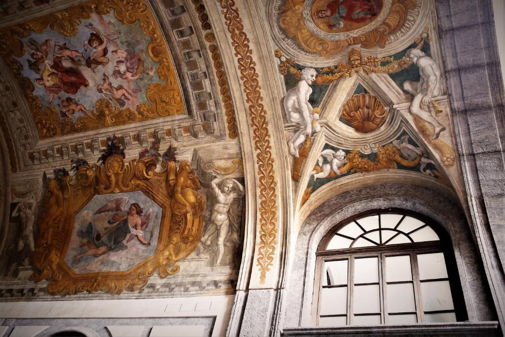 Cette chambre est dotée de peintures murales et d'une fenêtre. dans l'établissement Maison Des Fleurs, à Naples