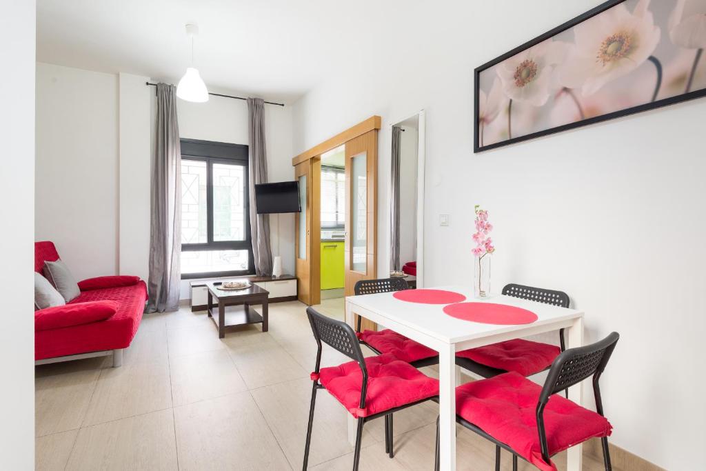 salon z białym stołem i czerwonymi krzesłami w obiekcie MABB-Quiet Apt With Private Patio Walking Distance To Downtown w Maladze