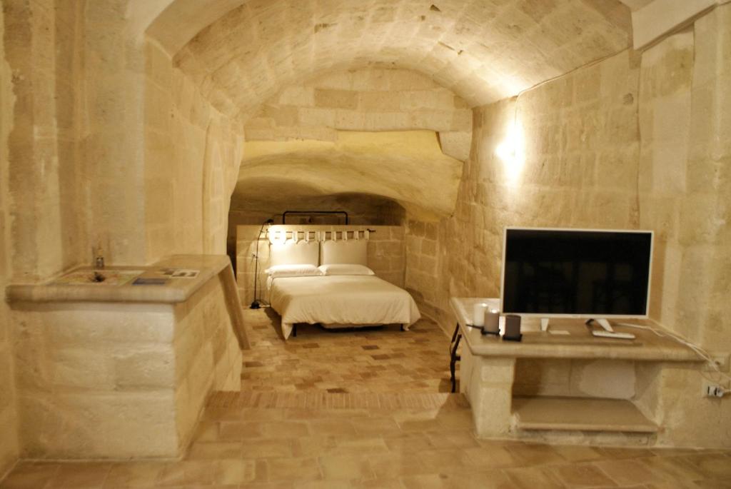 een slaapkamer met een bed, een wastafel en een tv bij Casa Ferri in Matera