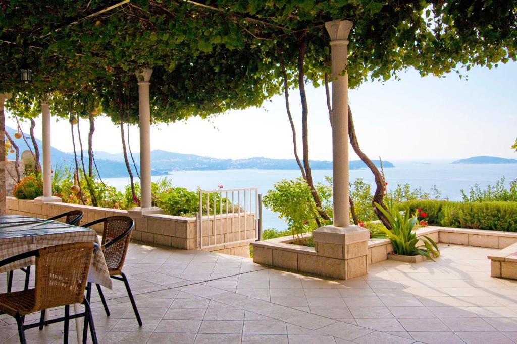 un patio con tavoli, sedie e vista sull'acqua di Guest house Burin a Mlini
