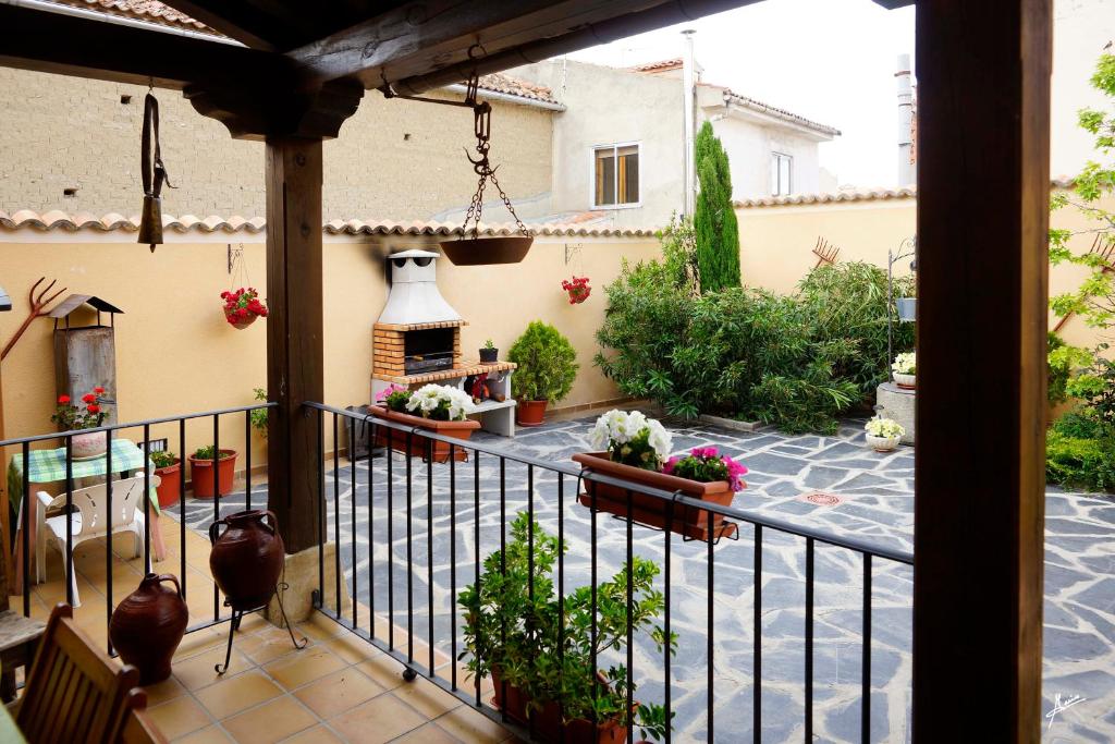 a balcony of a house with a courtyard with a fireplace at CASA RURAL LA FINCA DEL POZO in Segovia