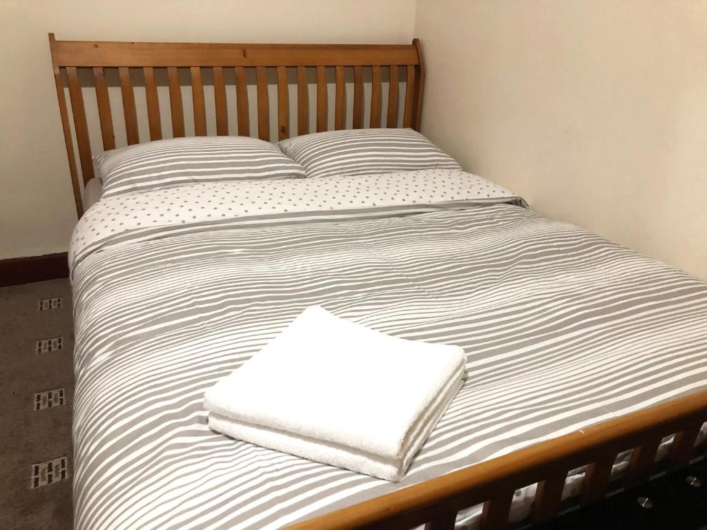a bed with two white towels sitting on it at The Guest House in Luton