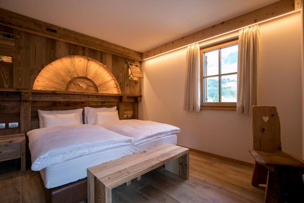 Un dormitorio con una cama grande y una ventana en Agriturismo Malga Piè, en Soraga