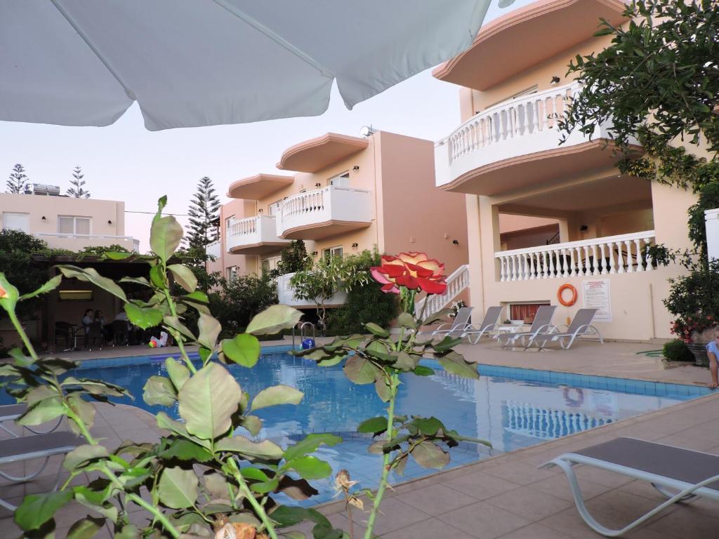 Blick auf ein Hotel mit Pool in der Unterkunft Golden Rose Suites in Kolimvárion