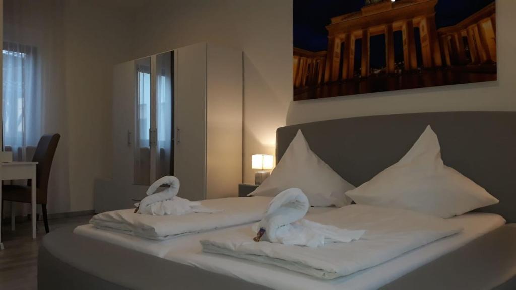 two swans are sitting on a bed with towels at Das SP Hotel in Fürth