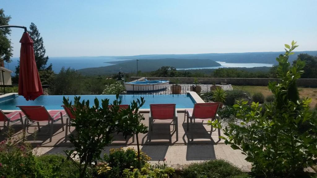 a patio with chairs and a swimming pool at Villa Olea in Koromačno