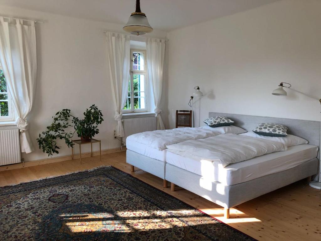 ein Schlafzimmer mit einem weißen Bett und einem Teppich in der Unterkunft Erzherzog-Johann Ferienhaus mit besonderem Flair in Stainz