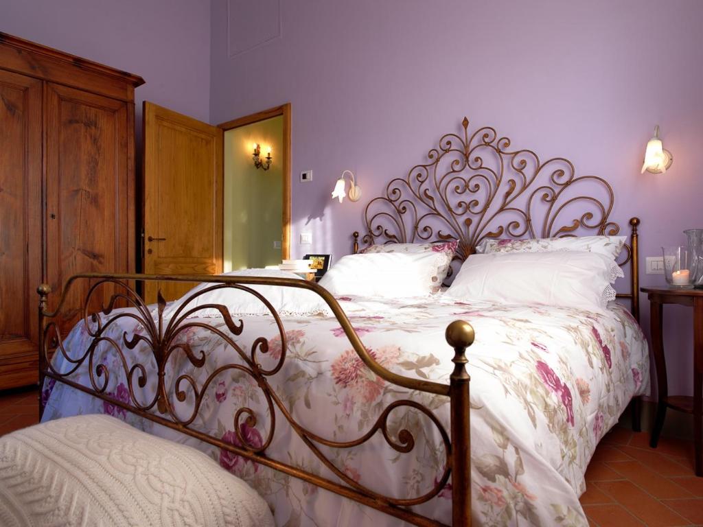 1 dormitorio con 1 cama grande con marco de metal en Podere Terreno alla via della volpaia en Radda in Chianti