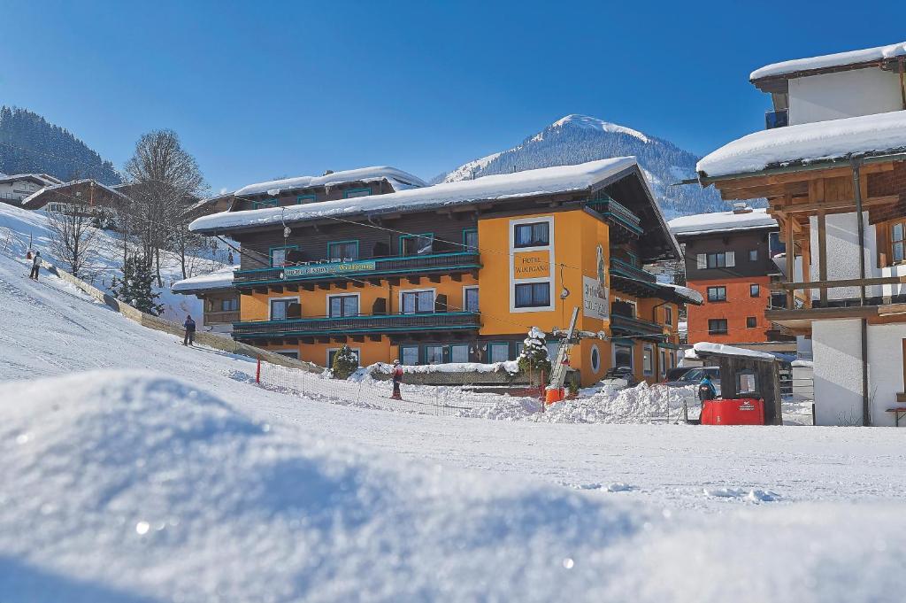 budynek na śniegu pokryty śniegiem zadaszone budynki w obiekcie Hotel Garni Wolfgang w Saalbach Hinterglemm