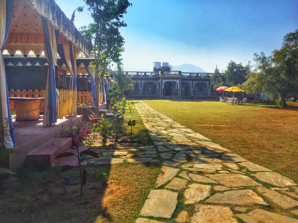 a stone walkway next to a building with a yard at Pushkar Vela Resort in Pushkar