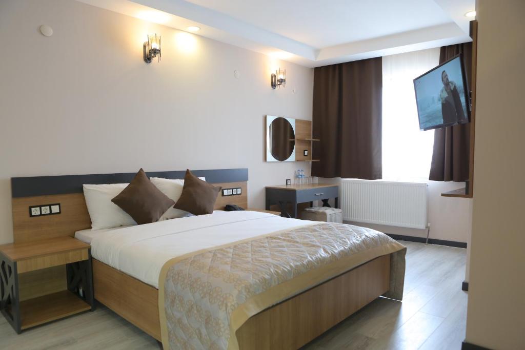 a hotel room with a bed and a television at KORKMAZ OTEL in Merzifon