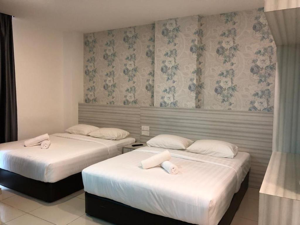 2 camas en una habitación de hotel con almohadas blancas en KU-3 HOTEL en Tapah