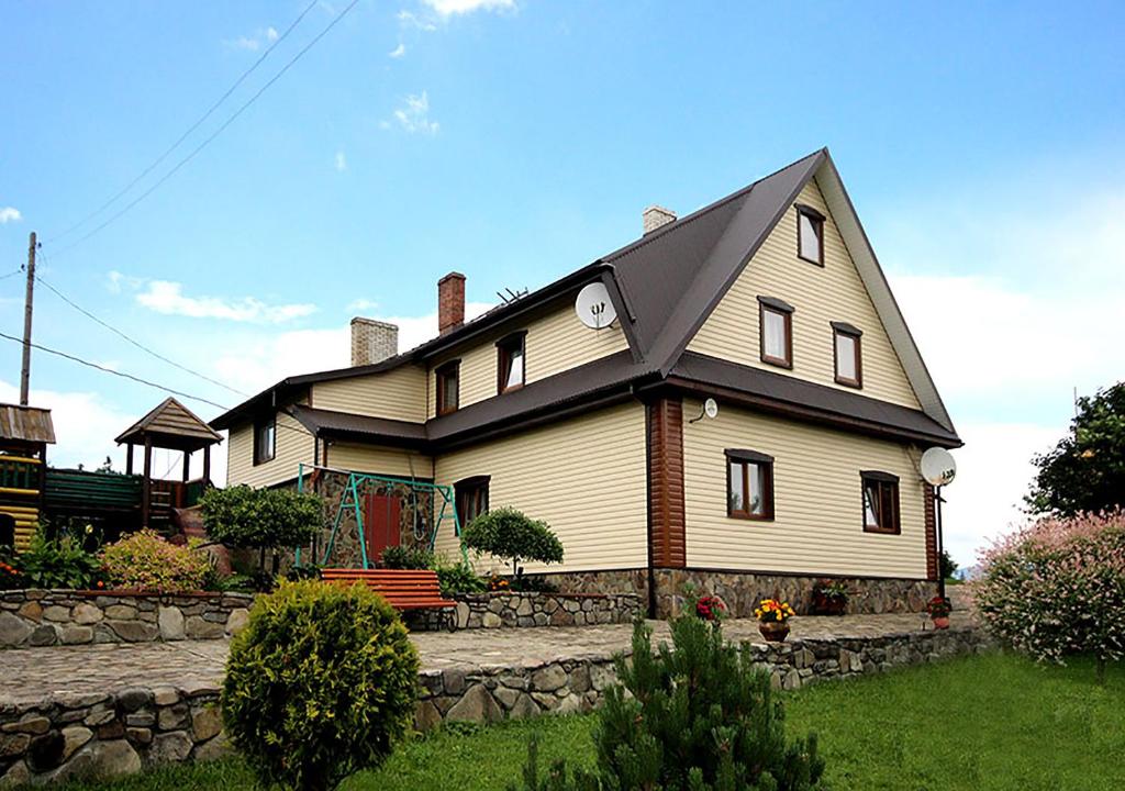 una gran casa blanca con techo de gambrel en Girskiy Svitanok, en Slavske