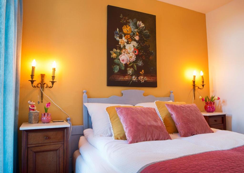 a bedroom with a bed with a painting on the wall at Maison la Tulipe in Zoutelande