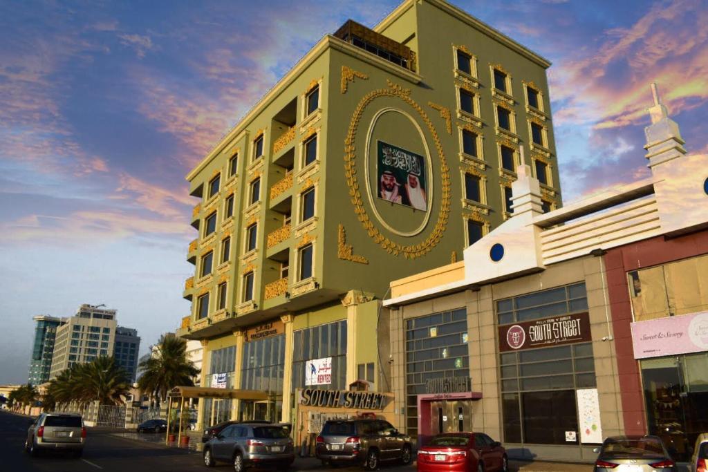 a green building with a clock on the side of it at LeChateau Boutique Hotel in Jeddah