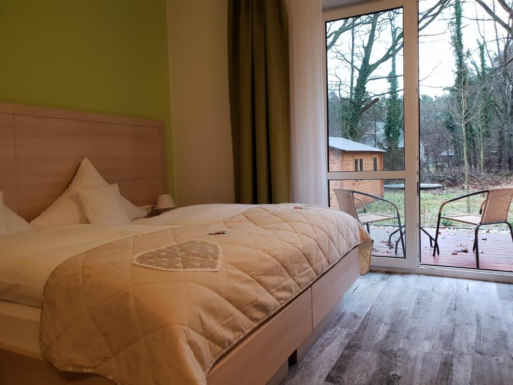 a bedroom with a bed and a large window at Neue Mühle Kleines Landhotel in Brandenburg an der Havel
