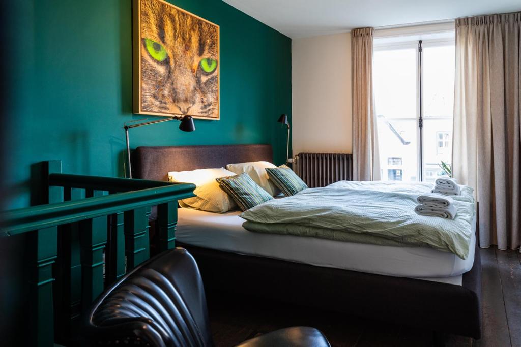 een slaapkamer met een bed en een groene muur bij B&B 'het Gripshuis' in Vught