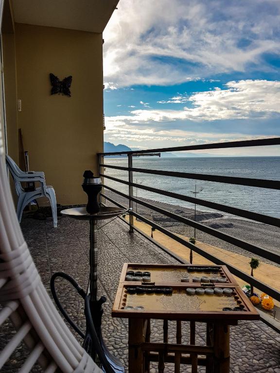 a table on a balcony with a view of the water at Hotel T Apartment in Gonio