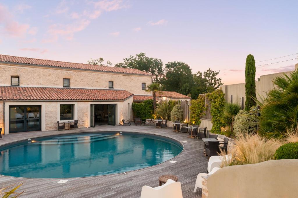 a swimming pool in a yard next to a building at The Originals Boutique, Hôtel La Grange, Niort (Qualys-Hotel) in Niort