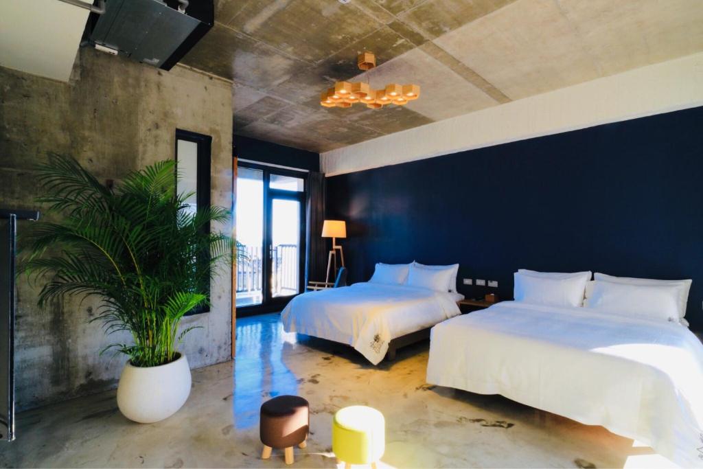 大漢村的住宿－七星潭泥作輕旅民宿，一间卧室设有两张床和盆栽植物