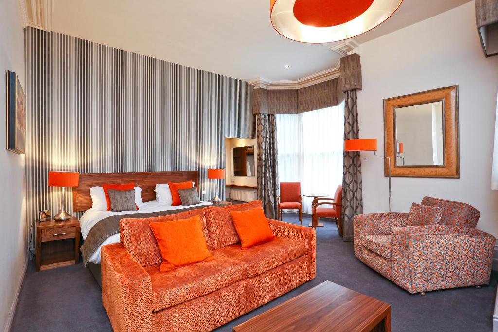 a hotel room with a bed and a couch at Belmont Hotel Leicester in Leicester