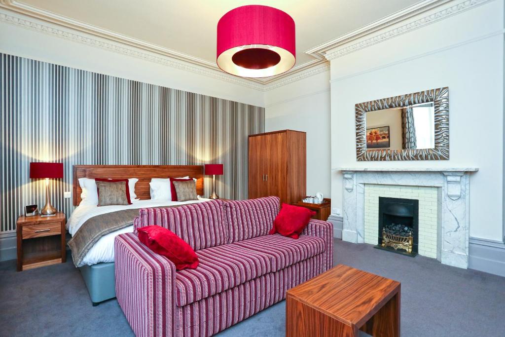 a living room with a couch and a bed at Belmont Hotel Leicester in Leicester