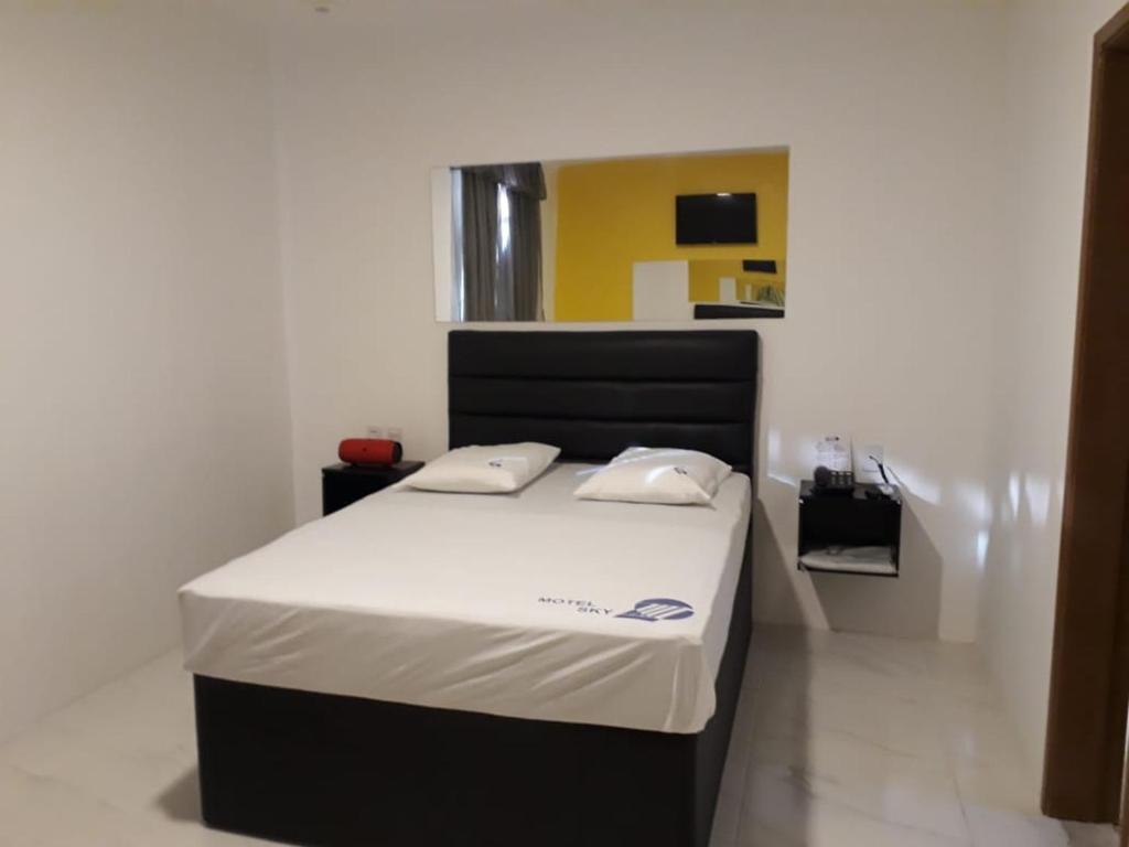 uma cama com duas almofadas num quarto em Motel Sky (Adults Only) em Salvador