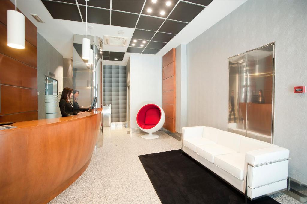 a woman sitting at a reception desk in a bathroom at Hotel Longoria Plaza by Pandora Hoteles in Oviedo