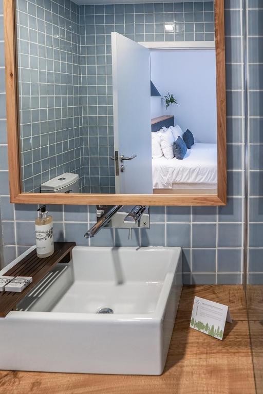 a bathroom with a white sink and a mirror at Furnas Lake Forest Living in Furnas