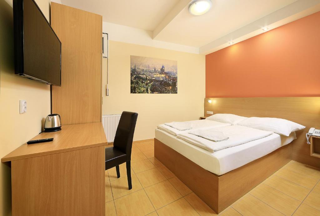 een slaapkamer met een bed en een bureau met een televisie bij Basement Room Old Town in Praag