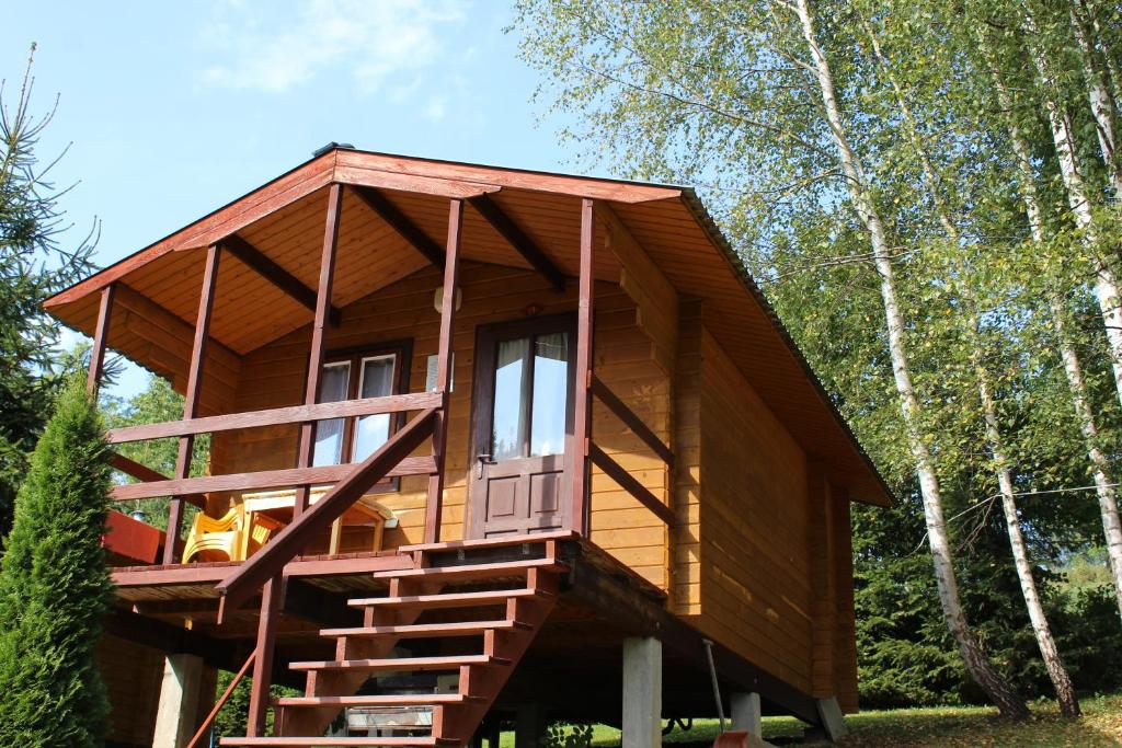 a tree house with stairs leading up to it at Domki Pod Wzgórzem in Polańczyk