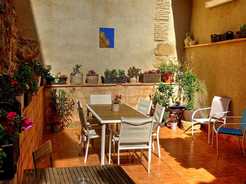 a table and chairs in a room with potted plants at La Casa de Anais in Abiego