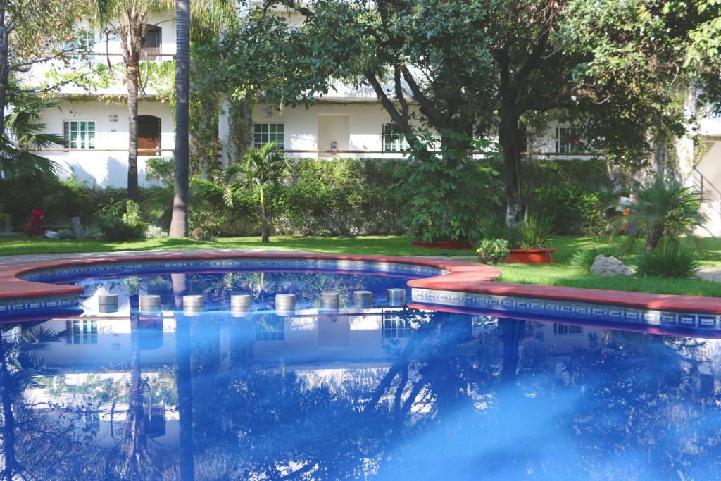 uma piscina num quintal com um edifício ao fundo em Áurea Hotel and Suites em Guadalajara