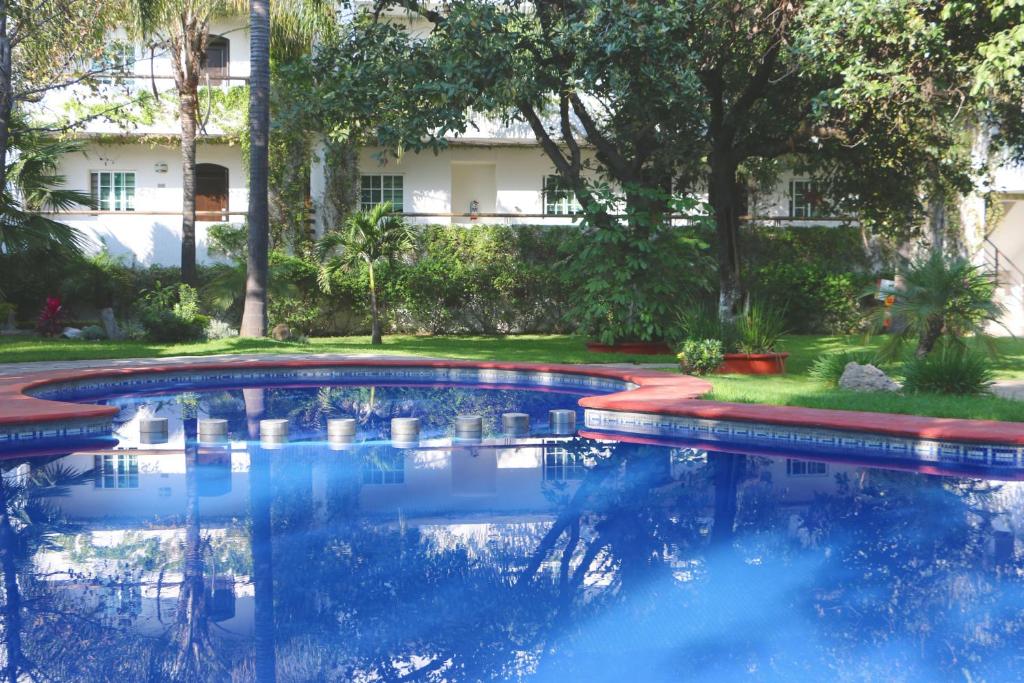 a swimming pool in a yard with a building in the background at Áurea Hotel and Suites in Guadalajara