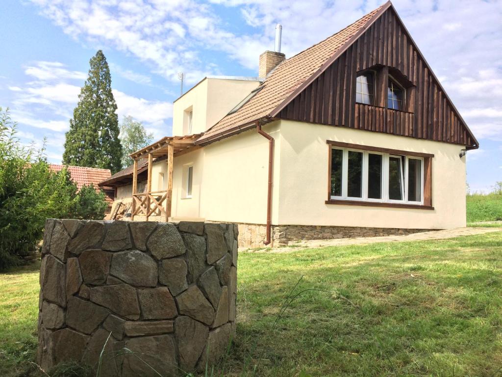 a house with a stone wall in front of it at NA SAMOTĚ U LESA in Komařice