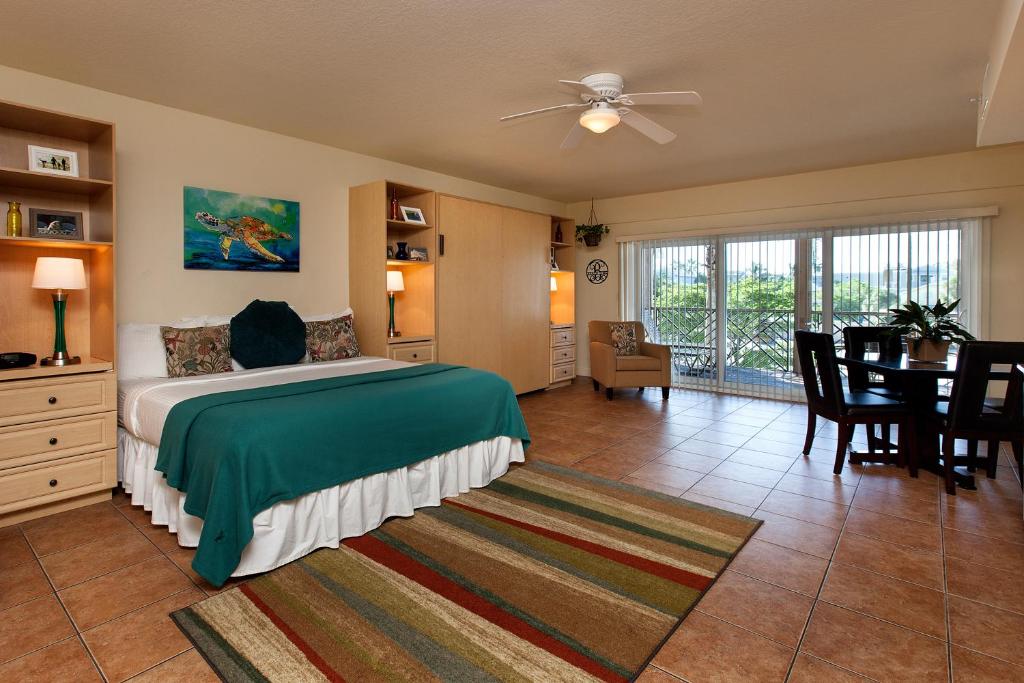 a hotel room with a bed, chair, and table at Bridgewalk, a Landmark Resort in Bradenton Beach