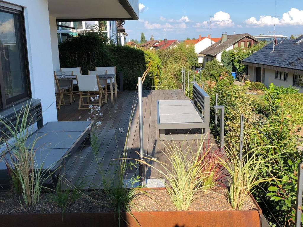 a deck with a table and chairs on a house at Wunderschönes Domizil auf der Höri am Bodensee in Gaienhofen