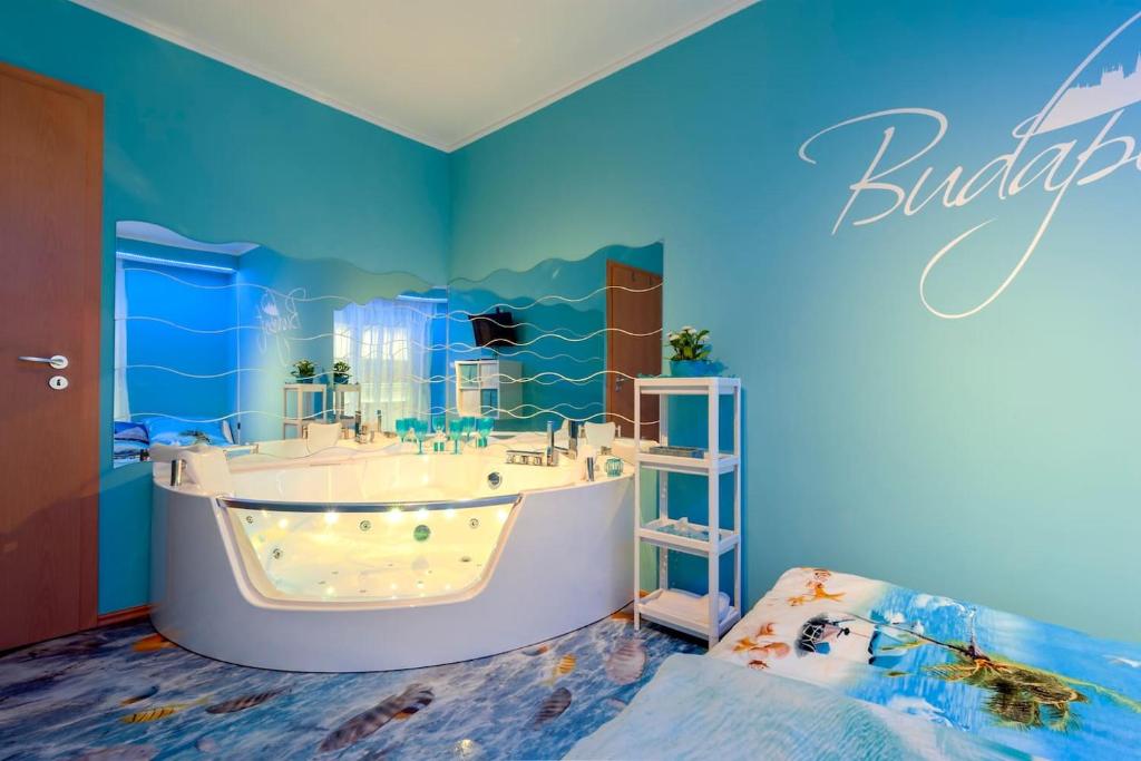 Baño azul con bañera y lavamanos en AquaFlat en Budapest