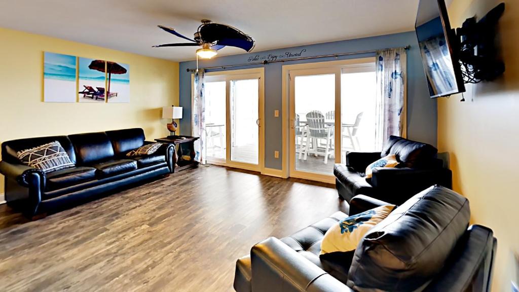 uma sala de estar com 2 sofás e uma ventoinha de tecto em Put-in-Bay Waterfront Condo #103 em Put-in-Bay