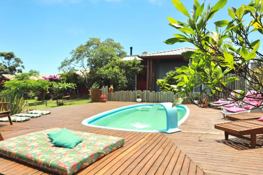 a swimming pool with a pool noodle in a backyard at Pousada Waikiki in Praia do Rosa