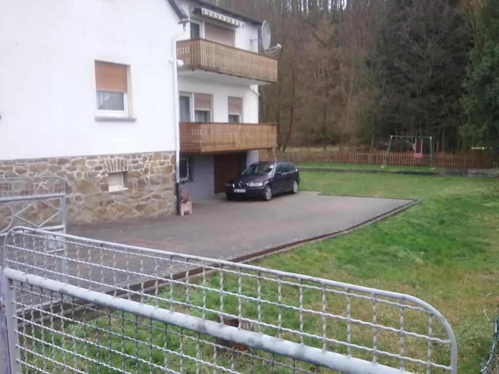 a car parked in the driveway of a house at Pension Ehringshausen in Ehringshausen