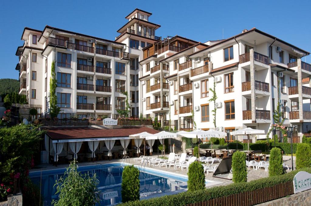 a hotel with a swimming pool in front of buildings at Mars Apartments in Tryavna Beach Complex in Sveti Vlas