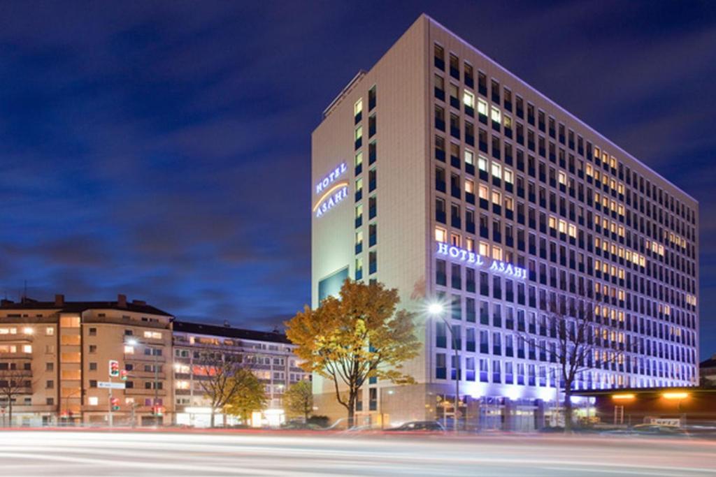 Un edificio alto con un cartel en la noche. en Hotel Asahi, en Düsseldorf